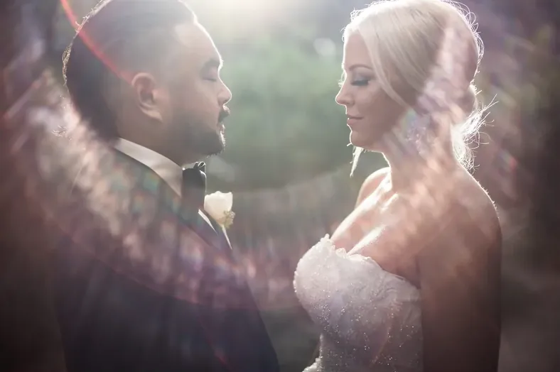 Couple in soft window light with a lens flare